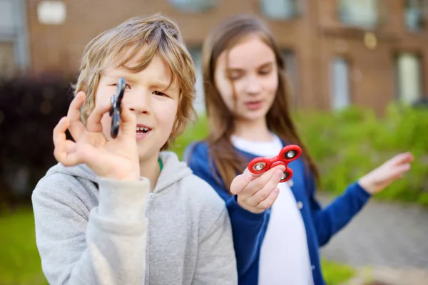 Dois amigos brincando com fidget spinners Fotos De Bancos De Imagens