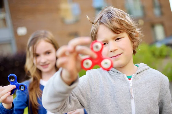 Dois amigos brincando com fidget spinners Imagens De Bancos De Imagens Sem Royalties