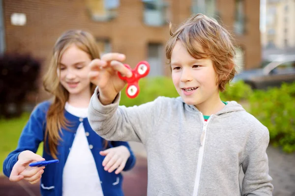 Dois amigos brincando com fidget spinners Fotos De Bancos De Imagens