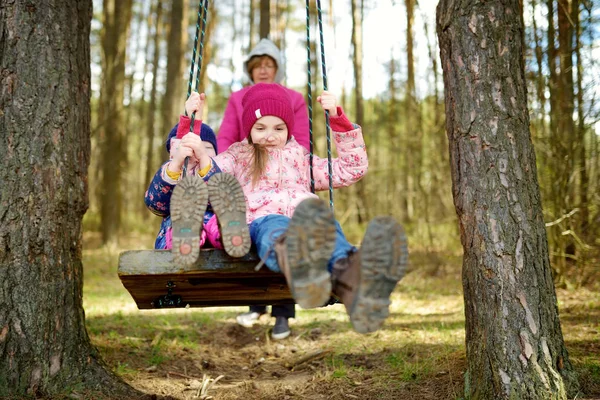 Little sisters having fun on swing — Stock Photo, Image