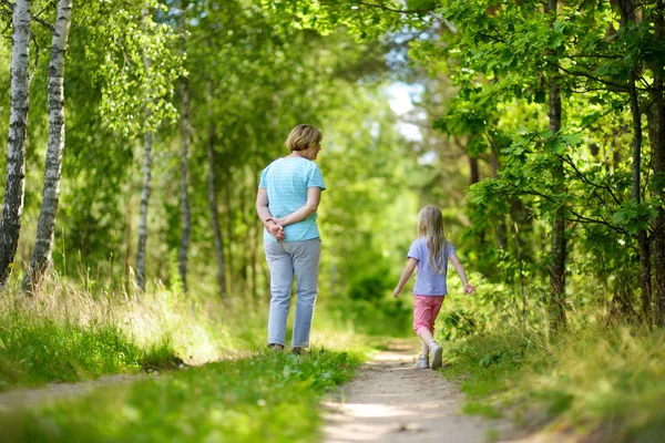 Meisje met oma wandelen in het bos — Stockfoto