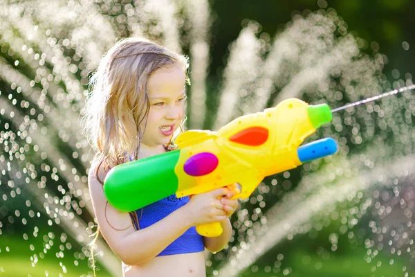 Meisje spelen met water gun automatische waterpistool — Stockfoto