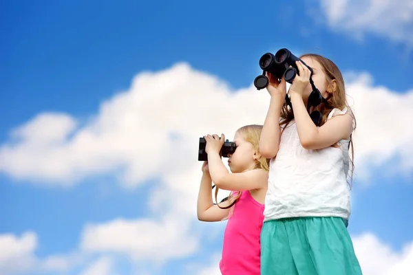 Girls looking through binoculars — Stock Photo, Image