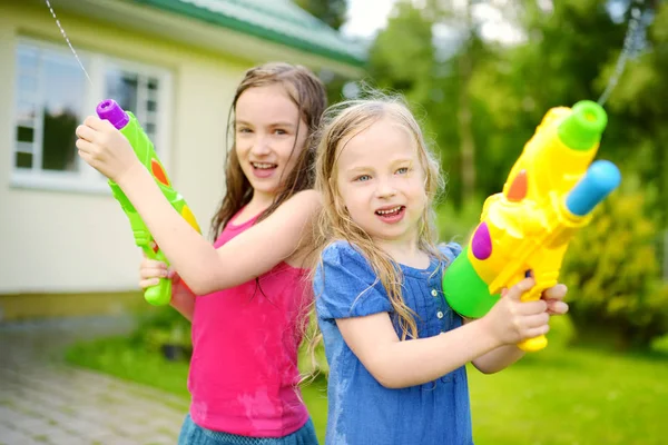 Zusters spelen met water pistolen — Stockfoto