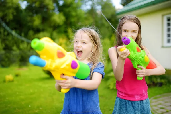 Zusters spelen met water pistolen — Stockfoto