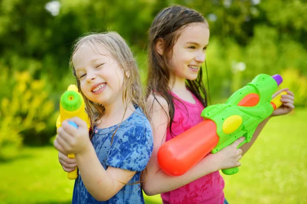Sisters playing with water guns — Stock Photo, Image