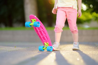 Kız parkta kaykay için öğrenme