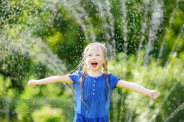 Bambina che gioca con l'irrigatore — Foto Stock