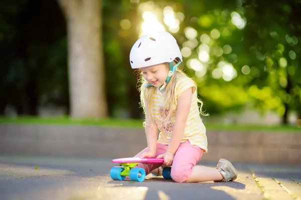 Menina sentada no skate no parque — Fotografia de Stock