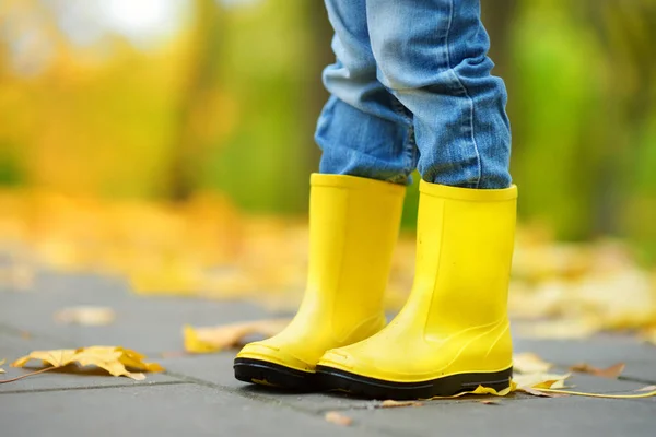 Botas de borracha amarela na estrada — Fotografia de Stock