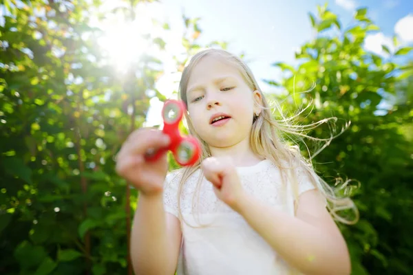 Meisje spelen met kleurrijke fidget spinner — Stockfoto