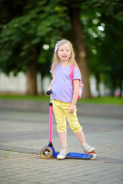 Ребенок позирует со скутером в городском парке — стоковое фото
