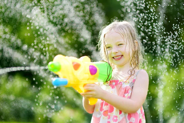 Dziewczyna bawi sie z pistoletem na wodę — Zdjęcie stockowe