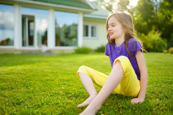 Schattig klein meisje, zittend op het gras — Stockfoto
