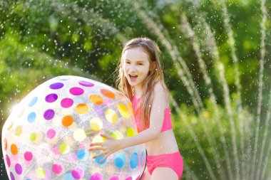  şişme plaj topu ile oynayan kız