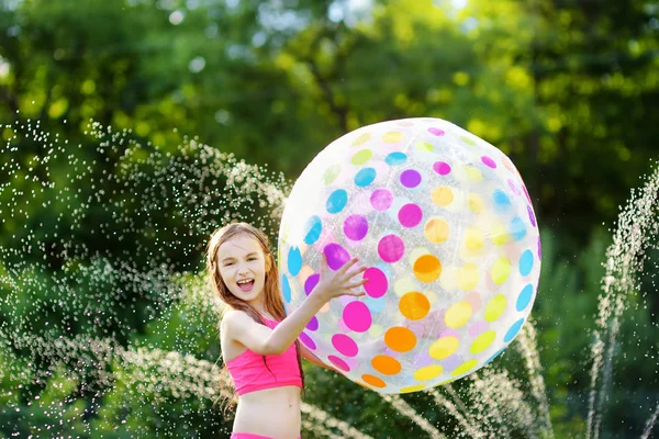Menina que joga com bola inflável da praia — Fotografia de Stock