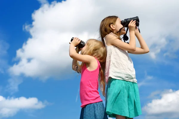 Girls looking through binoculars — Stock Photo, Image