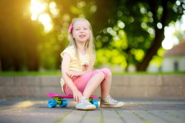 Kız parkta kaykay için öğrenme