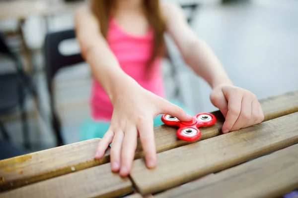 Chica jugando con colorido fidget spinner —  Fotos de Stock