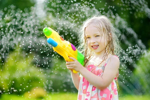 Funny child playing with water gun — Stock Photo, Image