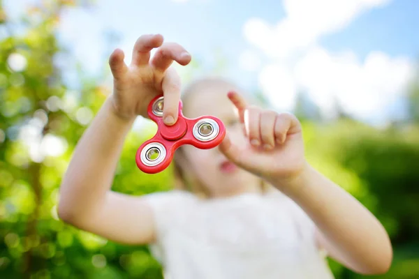 Chica jugando con colorido fidget spinner — Foto de Stock