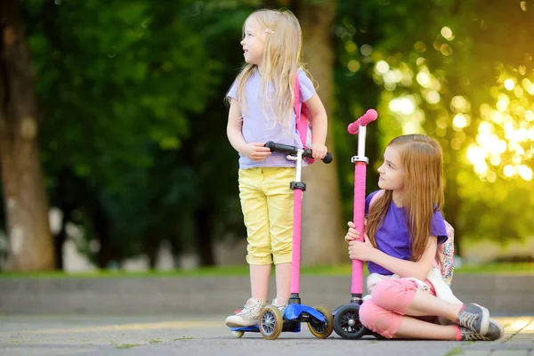Girls with scooters in city park — Stock Photo, Image
