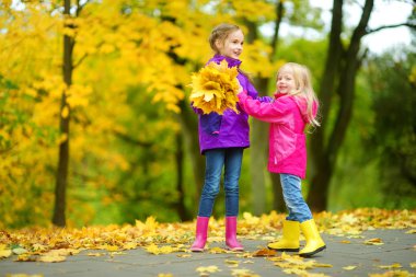 küçük kız sonbahar yaprakları ile oynamak 