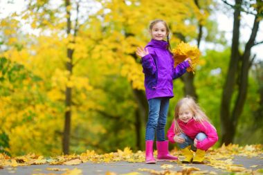 küçük kız sonbahar yaprakları ile oynamak 