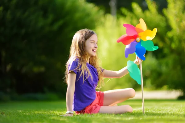 Meisje bedrijf kleurrijke speelgoed pinwheel — Stockfoto