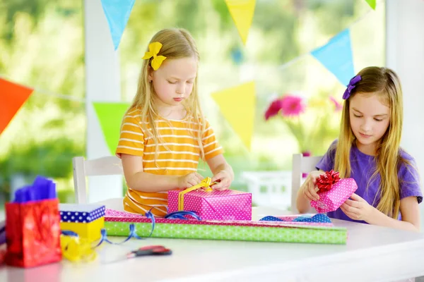 Hermanas pequeñas envolviendo regalos —  Fotos de Stock