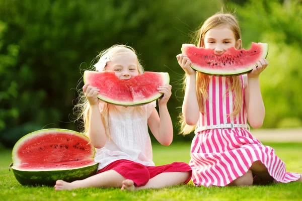 little sisters eating watermelon