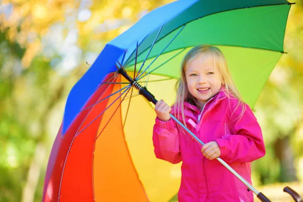 Menina segurando guarda-chuva arco-íris — Fotografia de Stock