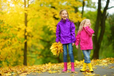 küçük kız sonbahar yaprakları ile oynamak 