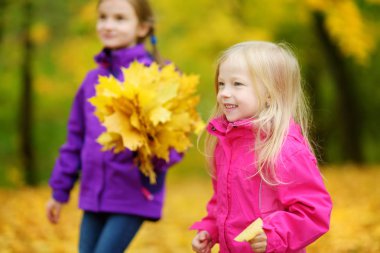 küçük kız sonbahar yaprakları ile oynamak 