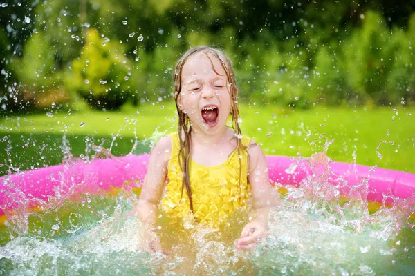 Menina jogando na piscina inflável do bebê — Fotografia de Stock