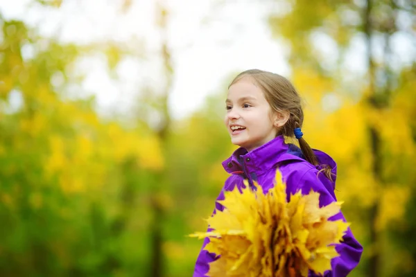 Klein meisje spelen met Herfstbladeren — Stockfoto