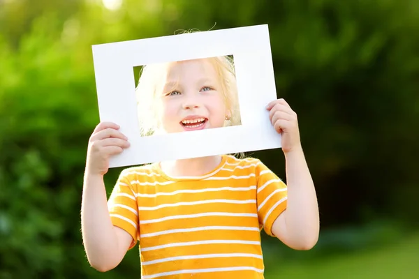 Niña sosteniendo marco blanco — Foto de Stock