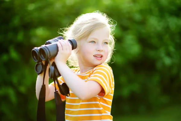 Liten flicka tittar genom kikare — Stockfoto