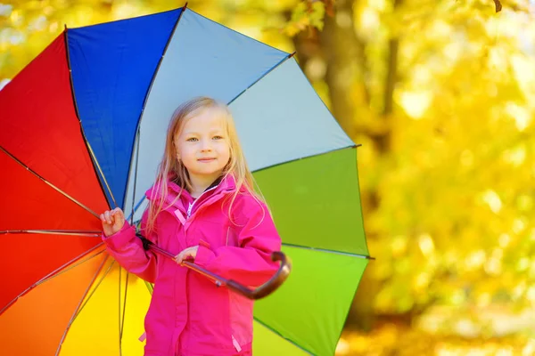 Mała dziewczynka trzymając parasol rainbow — Zdjęcie stockowe