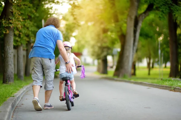 Pai ensinando filha a andar de bicicleta — Fotografia de Stock