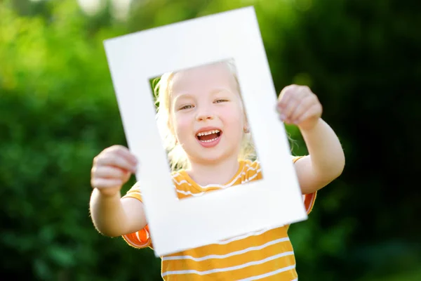 Kleine meisje bedrijf wit frame — Stockfoto