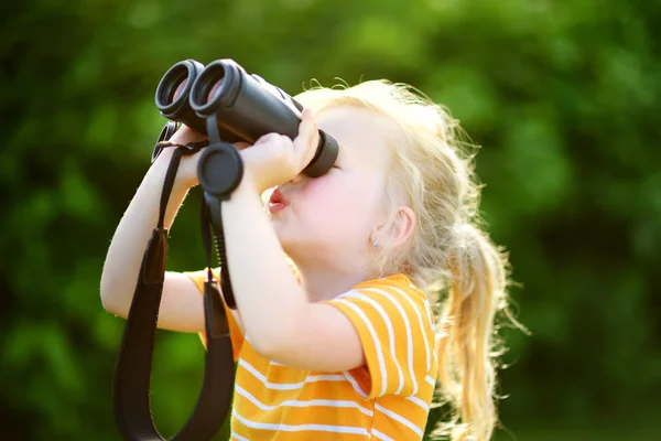 Liten flicka tittar genom kikare — Stockfoto