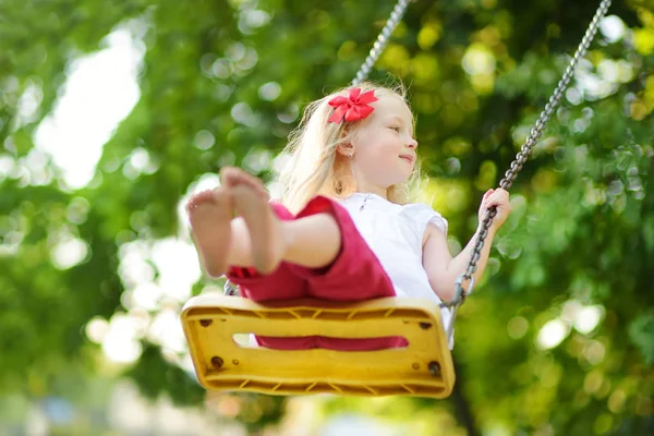 Mała dziewczynka huśtawka na placu zabaw — Zdjęcie stockowe
