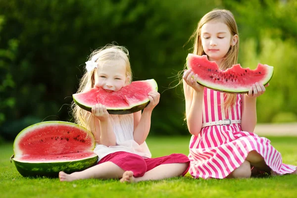 little sisters eating watermelon