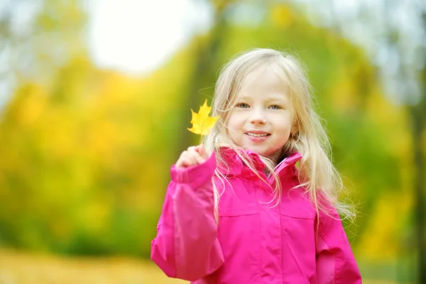 Kleines Mädchen spielt mit Herbstblatt — Stockfoto