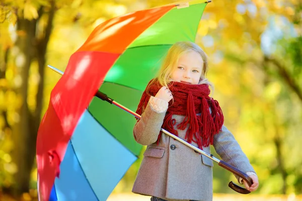 Menina segurando guarda-chuva arco-íris — Fotografia de Stock