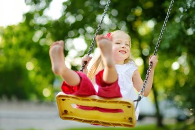 Küçük kız çocuk parkında sallanıyor
