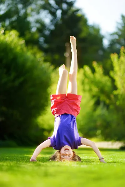 Fille jouer tête sur talons sur l'herbe — Photo