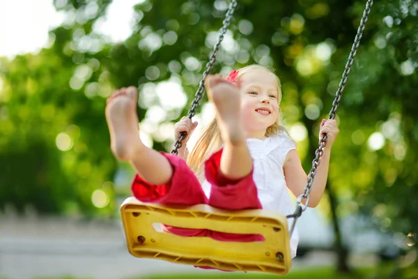 Küçük kız çocuk parkında sallanıyor — Stok fotoğraf
