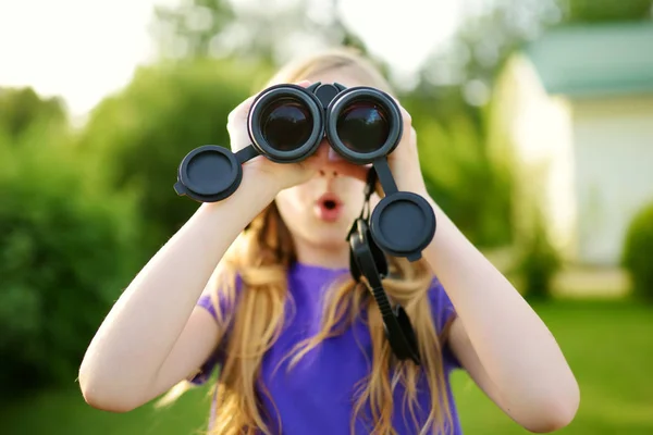 Liten flicka tittar genom kikare — Stockfoto